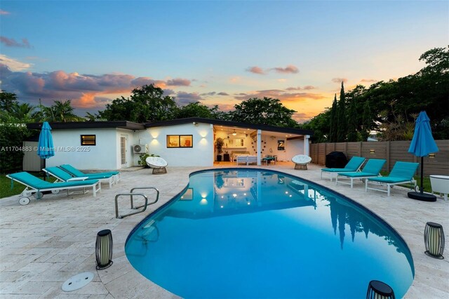 1805 Keystone Blvd, North Miami, FL 33181 - pool at dusk with an outdoor living space, a fenced backyard, a fenced in pool, and a patio area