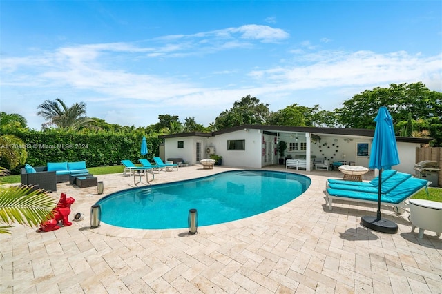 view of pool with an outdoor living space, a grill, and a patio