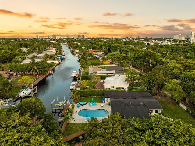 aerial view at dusk featuring a water view