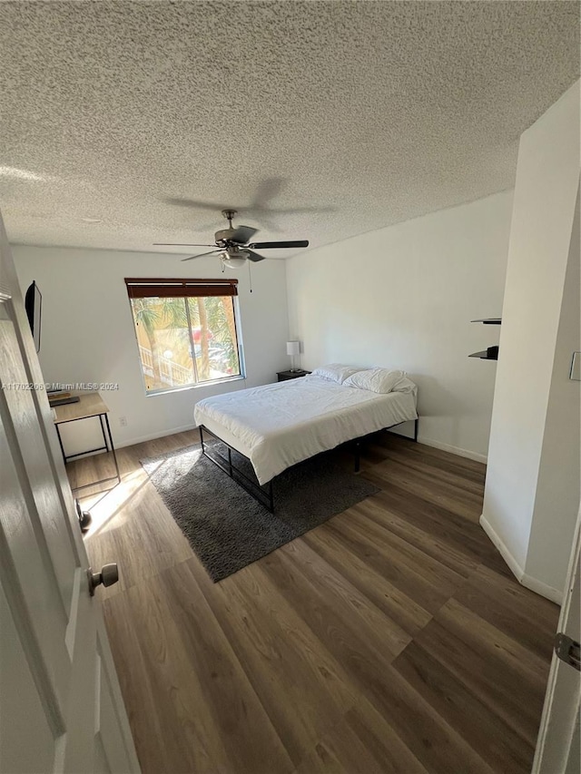 bedroom featuring a textured ceiling, ceiling fan, and dark wood-type flooring