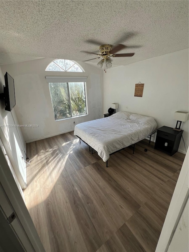 bedroom featuring hardwood / wood-style floors, a textured ceiling, and ceiling fan