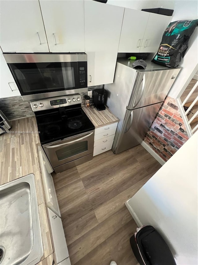 kitchen featuring dark hardwood / wood-style flooring, white cabinets, and stainless steel appliances