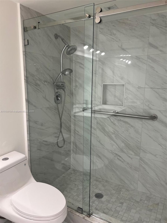 bathroom featuring toilet and walk in shower