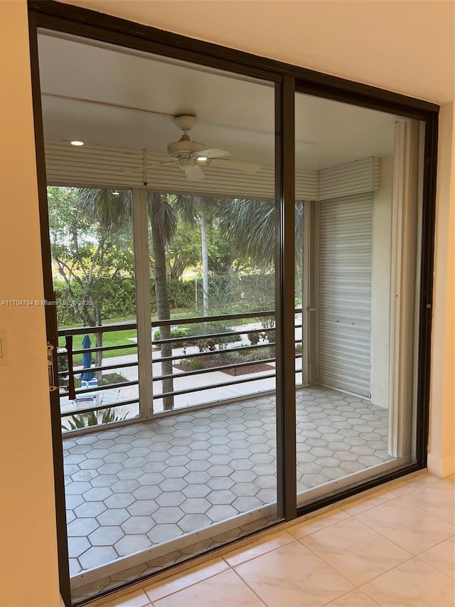 doorway with plenty of natural light, ceiling fan, and light tile patterned floors