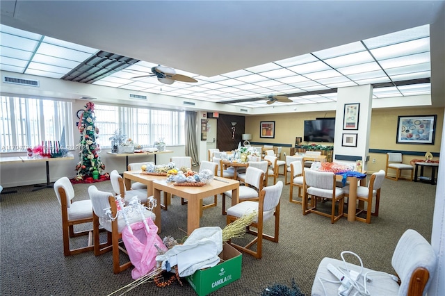 carpeted dining area with ceiling fan