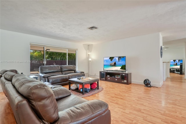 living room featuring a textured ceiling and light hardwood / wood-style flooring