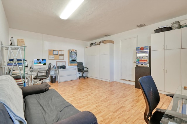 home office featuring a textured ceiling and light hardwood / wood-style flooring