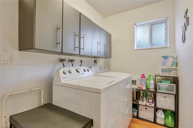 laundry room with separate washer and dryer, cabinets, and light hardwood / wood-style floors