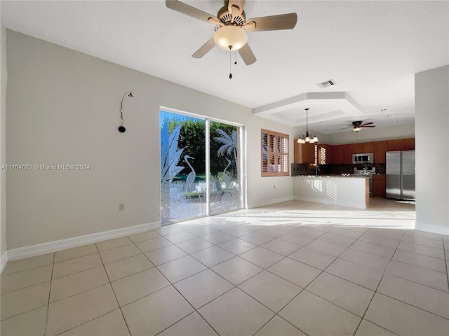 unfurnished living room with sink, light tile patterned floors, and ceiling fan with notable chandelier