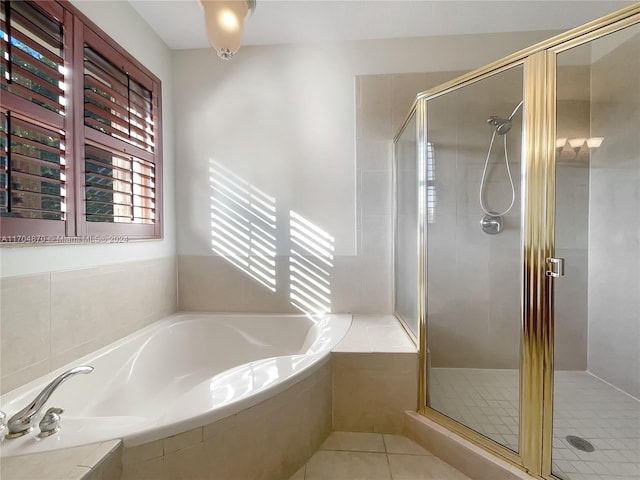 bathroom with tile patterned flooring and shower with separate bathtub