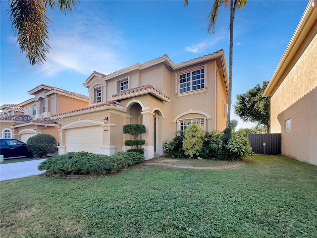 mediterranean / spanish home featuring a front yard and a garage