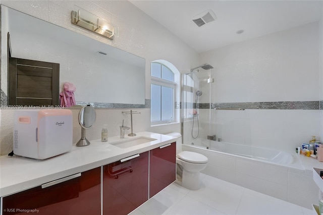 full bathroom featuring tile patterned floors, tiled shower / bath combo, toilet, and vanity