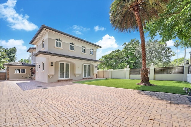 back of house featuring a yard and french doors