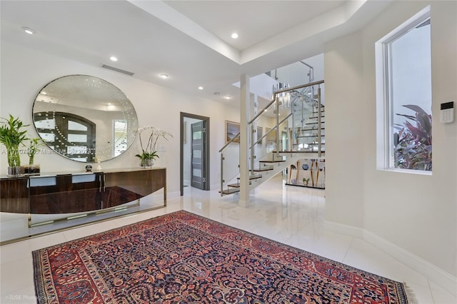 hallway featuring tile patterned floors and a tray ceiling