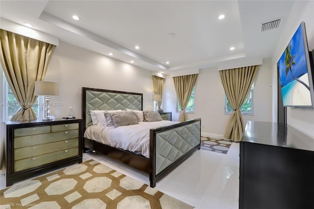 bedroom featuring a raised ceiling and light tile patterned flooring