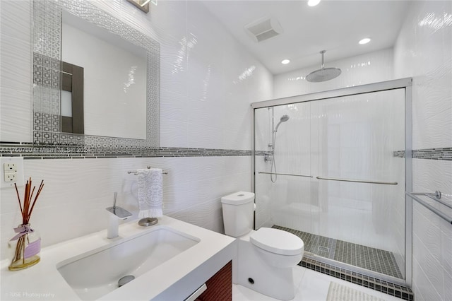 bathroom featuring an enclosed shower, vanity, toilet, and tile walls