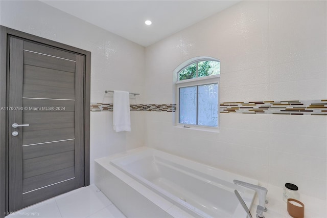 bathroom with tile patterned floors and a tub