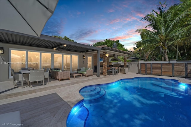 pool at dusk featuring a patio, an outdoor hangout area, and area for grilling