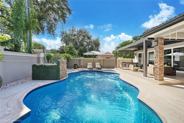 view of pool with outdoor lounge area, ceiling fan, and a patio