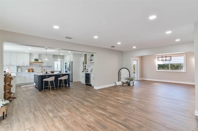 living room featuring wine cooler and light hardwood / wood-style flooring