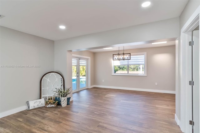 empty room with baseboards, wood finished floors, and french doors