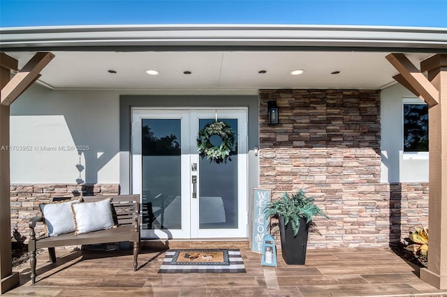 entrance to property featuring stone siding and french doors