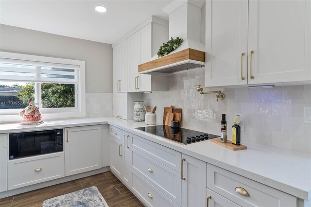 kitchen with custom range hood, dark hardwood / wood-style floors, white cabinetry, and black appliances