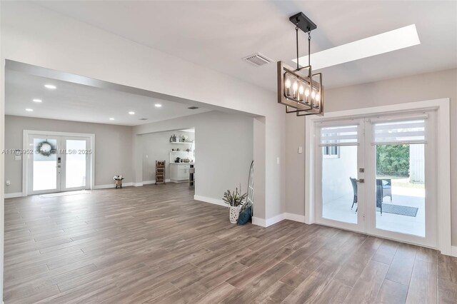 interior space featuring french doors, hardwood / wood-style flooring, and an inviting chandelier