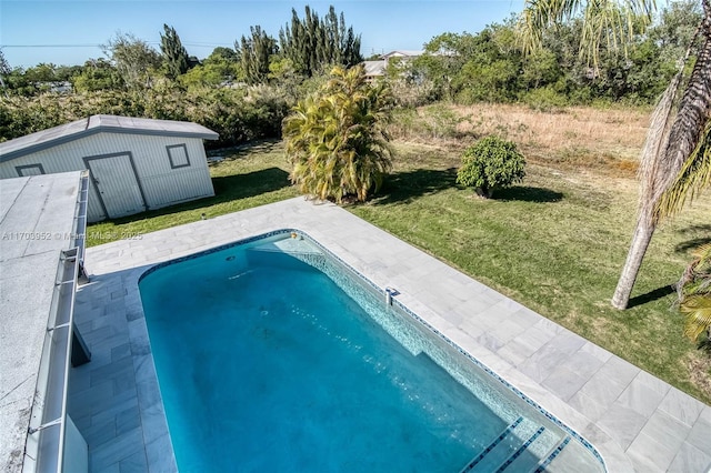 outdoor pool featuring a yard, a patio, and an outdoor structure