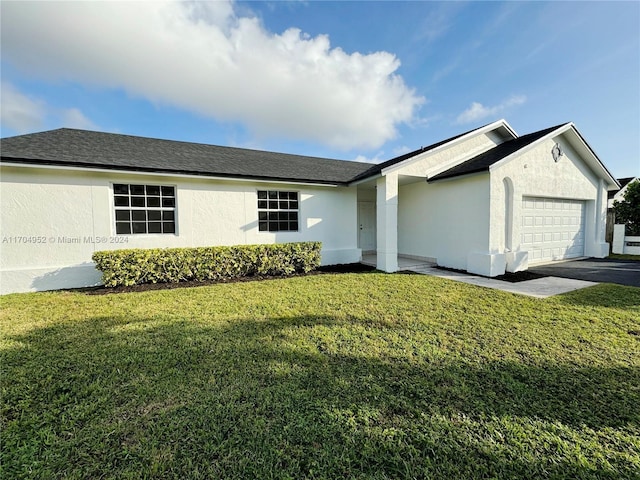 ranch-style home with a front lawn and a garage