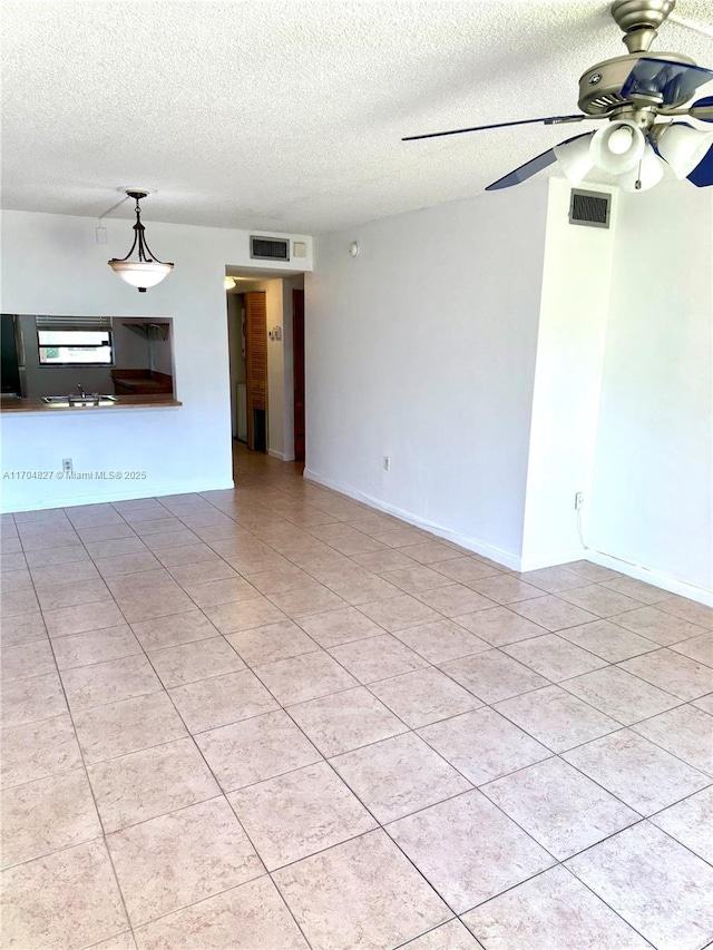137 NW 93rd Ave Unit 103, Pembroke Pines, FL 33024 - unfurnished living room featuring ceiling fan, a textured ceiling, tile patterned floors, and baseboards
