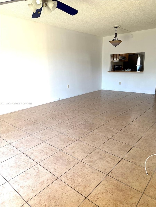 unfurnished room with ceiling fan and a textured ceiling