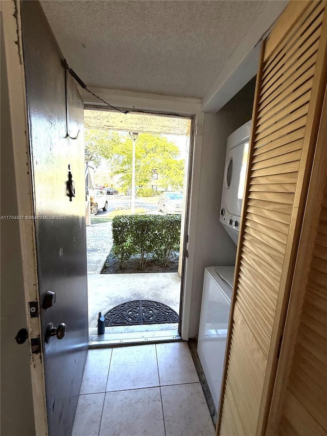 137 NW 93rd Ave Unit 103, Pembroke Pines, FL 33024 - washroom featuring estacked washer and dryer, a textured ceiling, and tile patterned floors