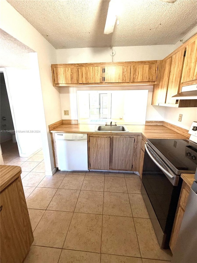 kitchen featuring sink, white dishwasher, a textured ceiling, stainless steel range with electric stovetop, and light tile patterned floors