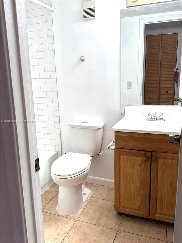 full bathroom featuring tile patterned floors, vanity, toilet, and tiled shower / bath combo