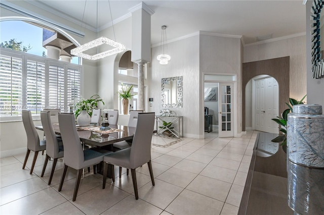 dining room featuring light tile patterned floors, an inviting chandelier, plenty of natural light, and crown molding