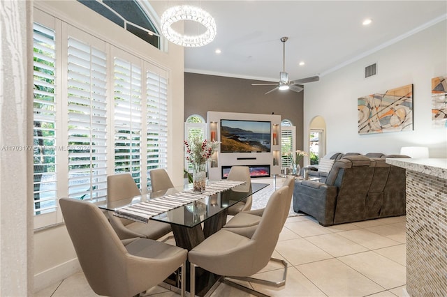 tiled dining space featuring ceiling fan and ornamental molding