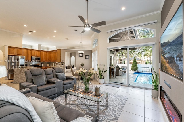 tiled living room featuring a high ceiling, ceiling fan, and crown molding