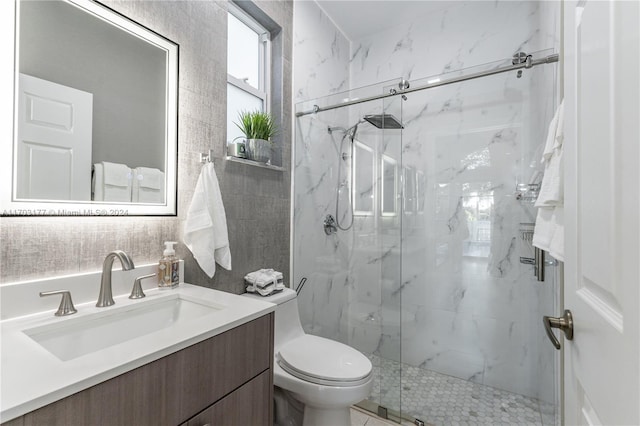 bathroom featuring vanity, toilet, and a shower with shower door