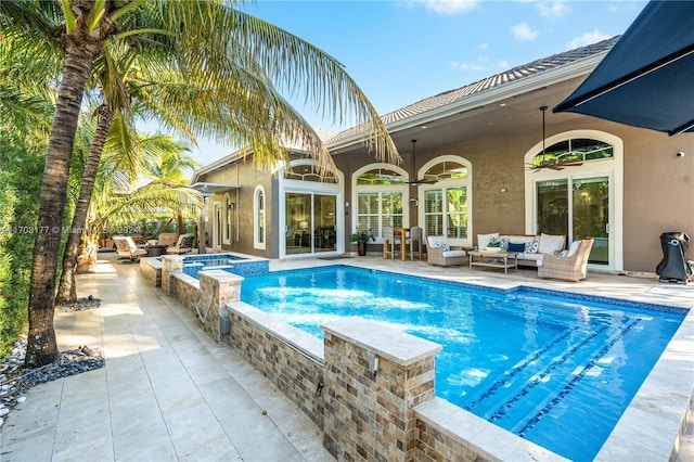 view of pool with an in ground hot tub, an outdoor living space, a patio, and ceiling fan