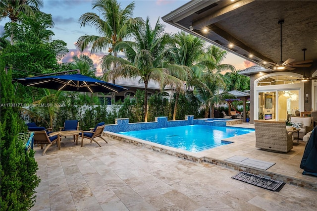 pool at dusk with ceiling fan, an outdoor hangout area, an in ground hot tub, and a patio