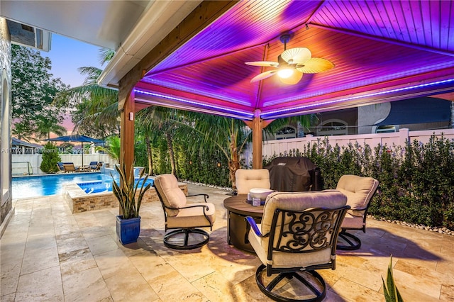 patio terrace at dusk with a fenced in pool, area for grilling, and ceiling fan