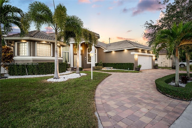 mediterranean / spanish-style house with a lawn and a garage