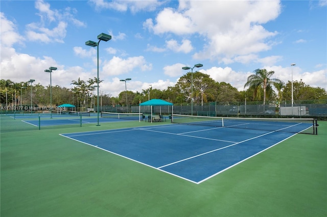 view of tennis court featuring basketball hoop