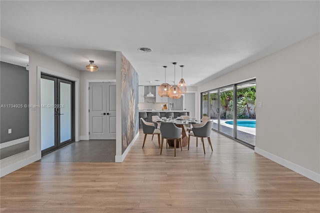 unfurnished dining area featuring french doors and light wood-type flooring