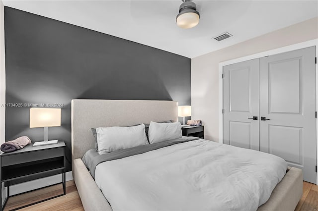 bedroom featuring ceiling fan, a closet, and light wood-type flooring