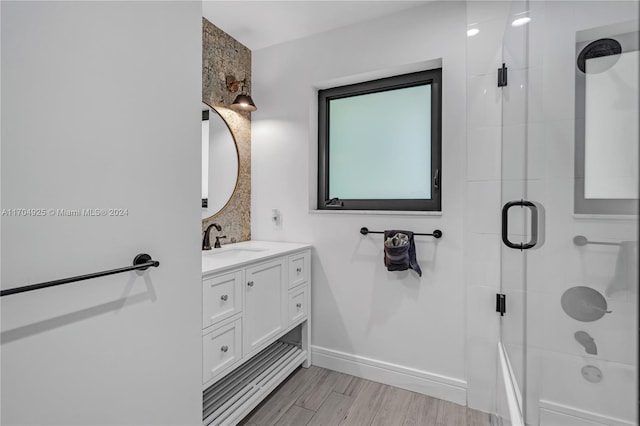 bathroom with hardwood / wood-style floors, vanity, and a shower with door