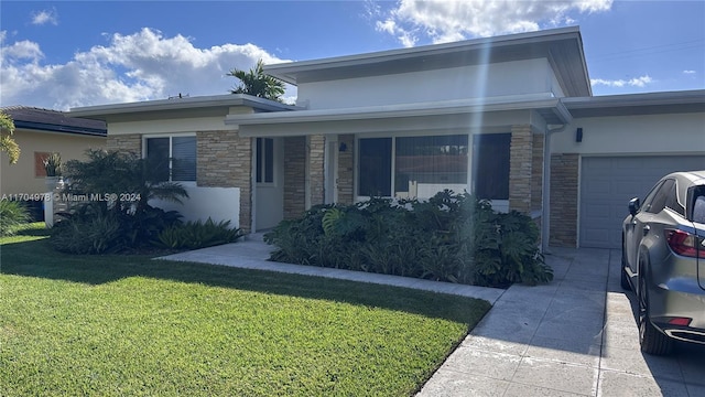 view of front of home with a front yard and a garage