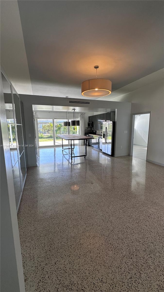 kitchen featuring stainless steel fridge, pendant lighting, and a healthy amount of sunlight