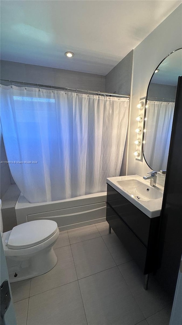 full bathroom featuring tile patterned flooring, vanity, toilet, and shower / bathtub combination with curtain